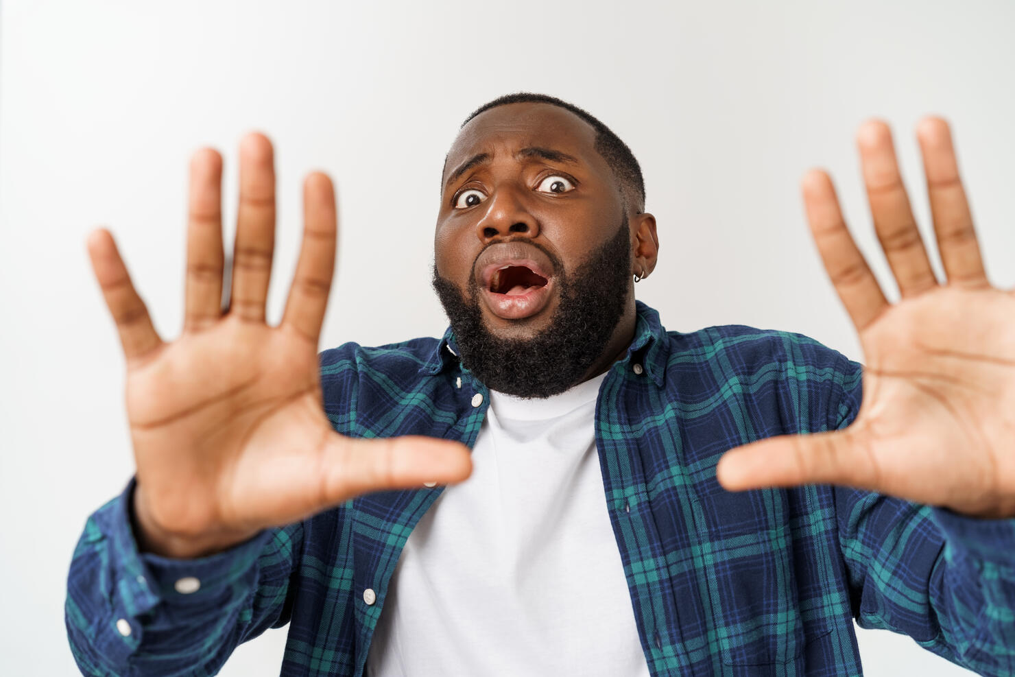 Portrait Of Scared Young Man Against White Backgrounds