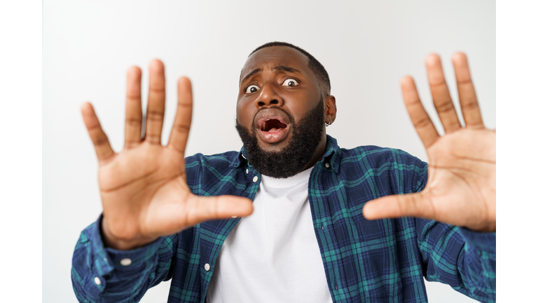 Portrait Of Scared Young Man Against White Backgrounds