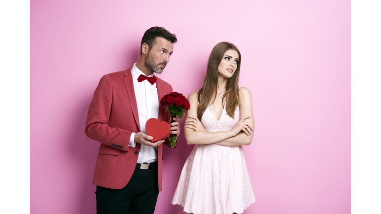Man with bunch of rose and chocolate box apologizing fiance