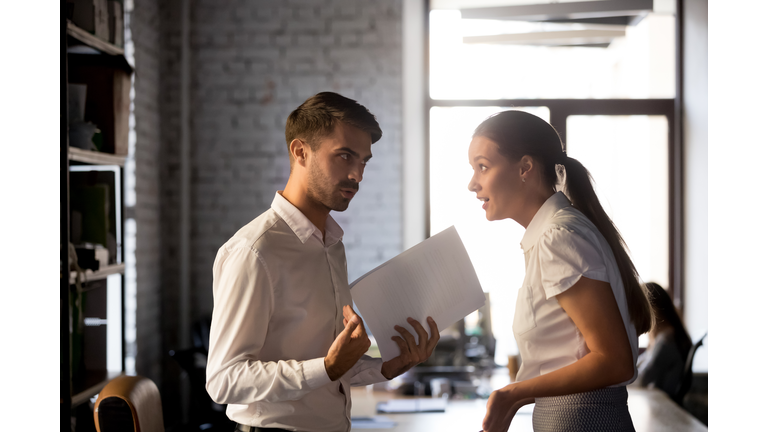 Diverse employees argue over financial report in office