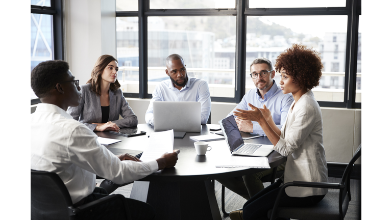 Millennial black businesswoman addressing colleagues at a corporate business meeting, close up