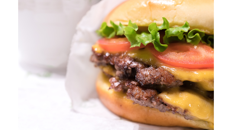 Double cheeseburger with tomato lettuce and onion, Cheese Fries and Milkshake.