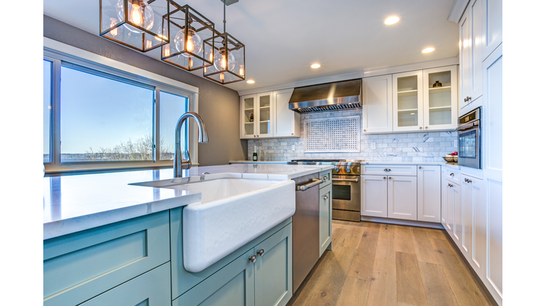 Beautiful kitchen room with green island and farm sink.