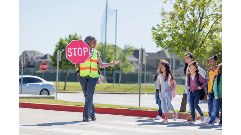 Crossing guard helps children on crosswalk