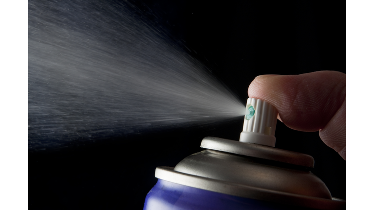 Spraying aerosol can isolated in black