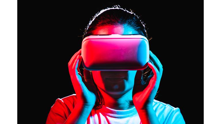 Woman using Virtual Reality headset at night