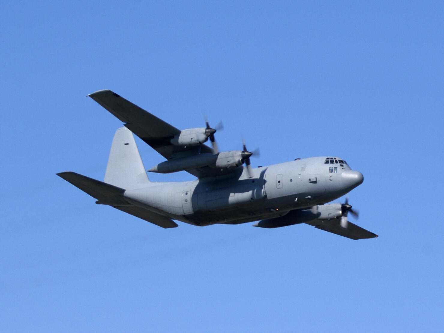 military cargo airplane Lockheed C130 Hercules flying in blue sky