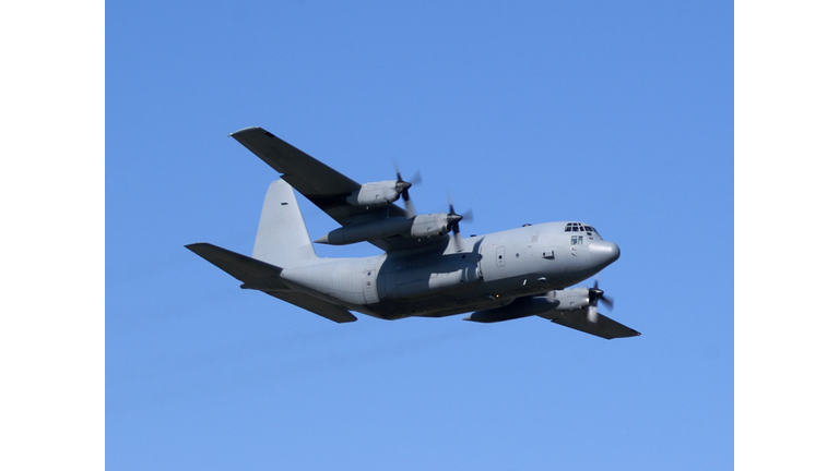 military cargo airplane Lockheed C130 Hercules flying in blue sky