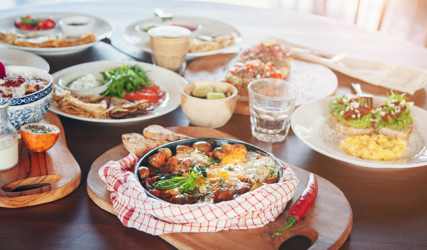 Brunch table with various dishes - fried eggs, crepes and tapas