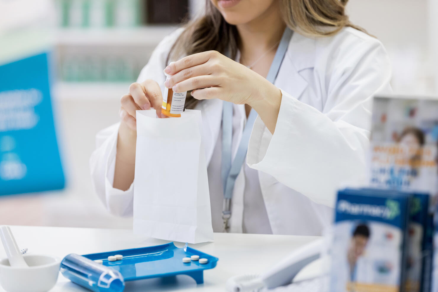 Pharmacist bags up a customer's prescription