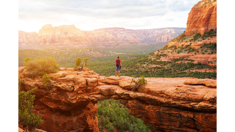 Travel in Devil's Bridge Trail, man Hiker with backpack enjoying view, Sedona, Arizona, USA