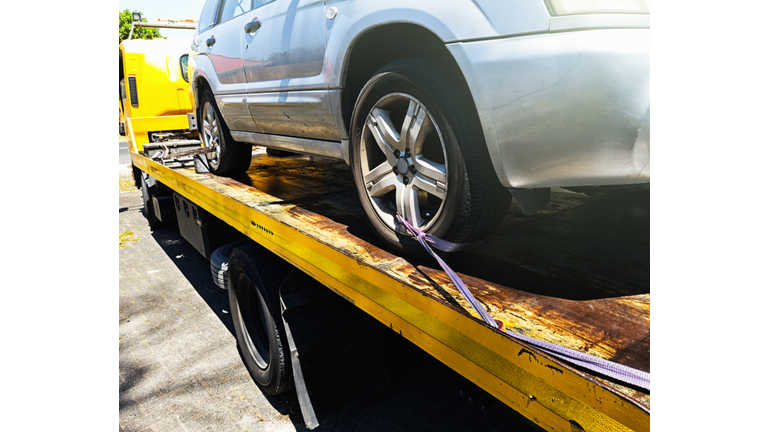 Car being attached to tow truck