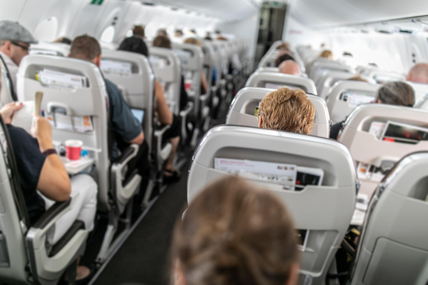 Interior of commercial airplane with passengers in their seats