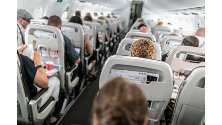 Interior of commercial airplane with passengers in their seats