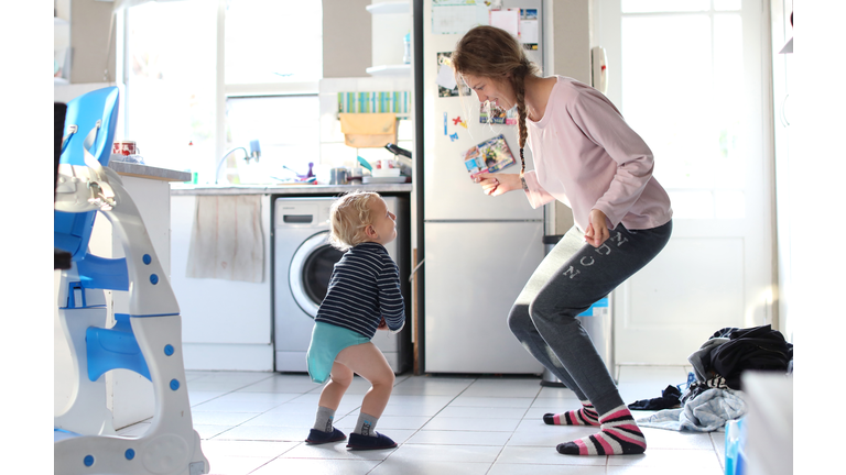 Mom and toddler dancing in the kitchen.