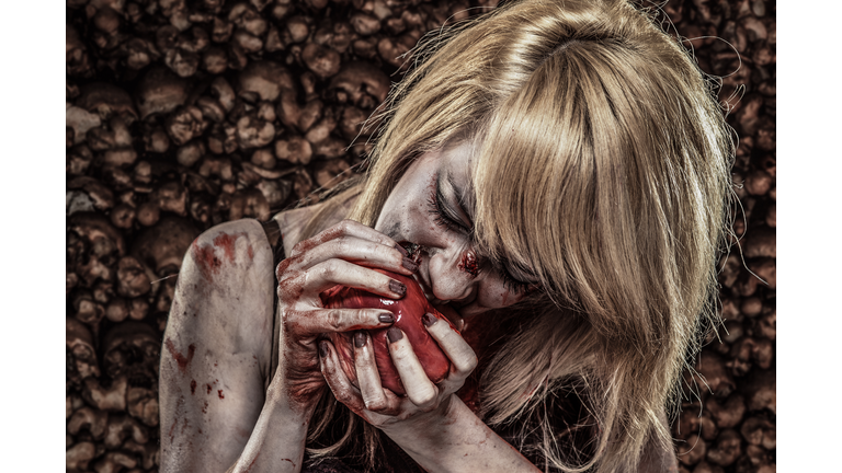 Young Zombie woman eating a Human Heart
