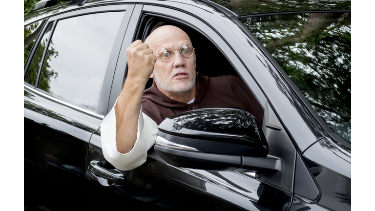 Mature man with road rage in a black car