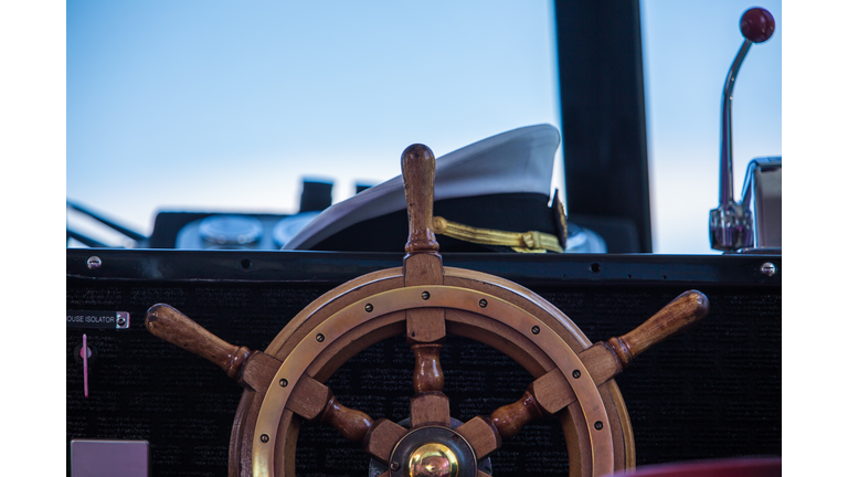 Wheel of small boat with captain's hat