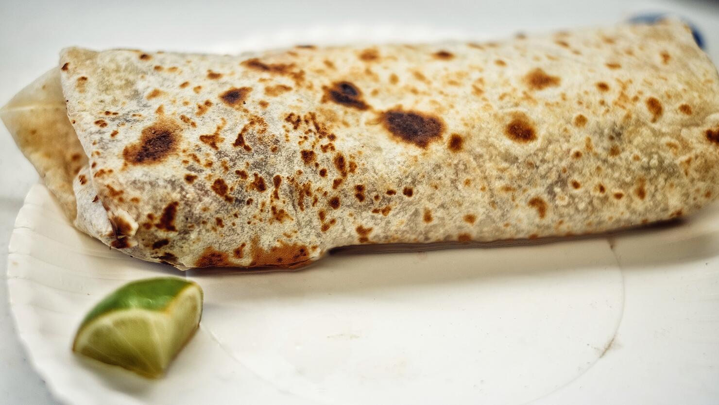 Close-Up Of Fresh Burrito With Lemon Piece Served In Plate