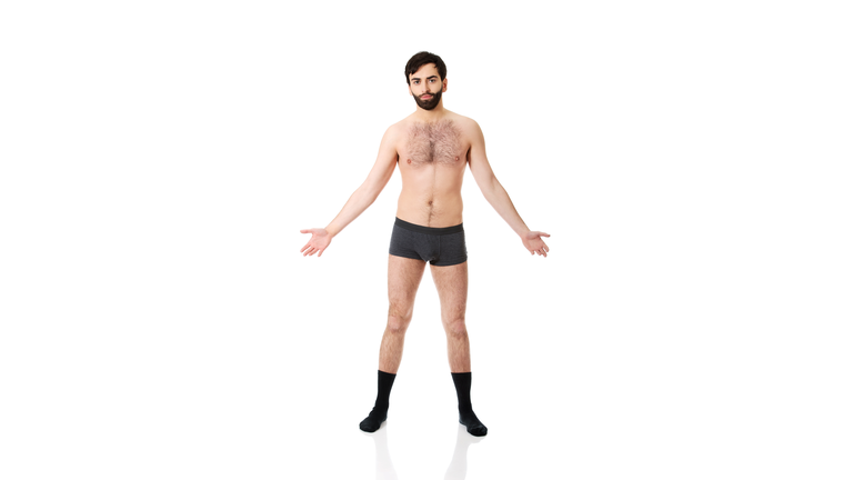 Portrait Of Man In Underwear Standing Against White Background