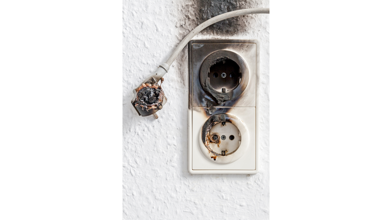 Close-up of electrical fire with the wire and wall plug