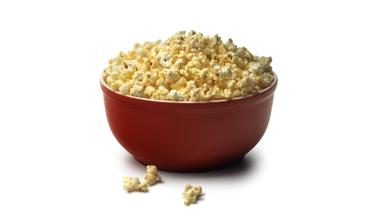 Red bowl of popcorn on a white background