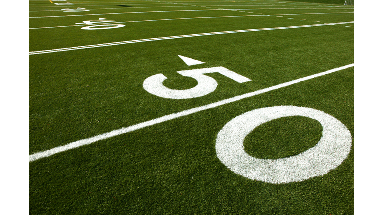 Green football field with white lines and numbers