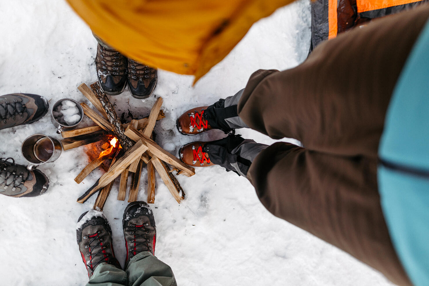 Tourists warming by campfire on snow