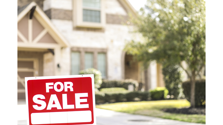 House for sale with real estate sign in yard.