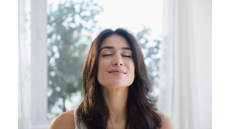 Calm woman breathing with eyes closed