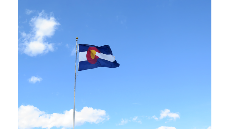 Colorado Flag waving in the wind against a Blue sky