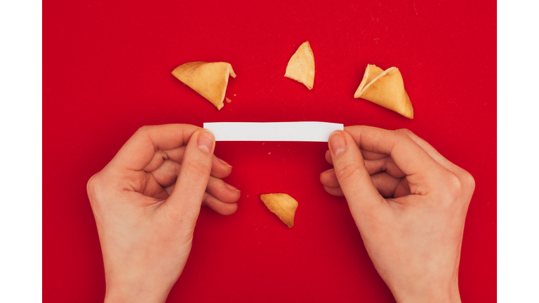 cropped shot of woman opening traditional fortune cookie, Chinese New Year concept