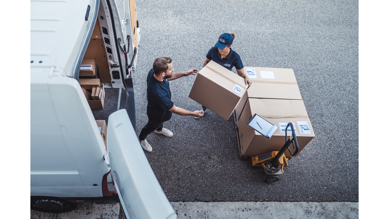 Coworkers rushing to load packages in a delivery van