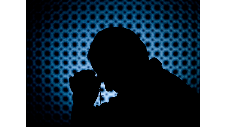 Priest in Confession Booth with Cross