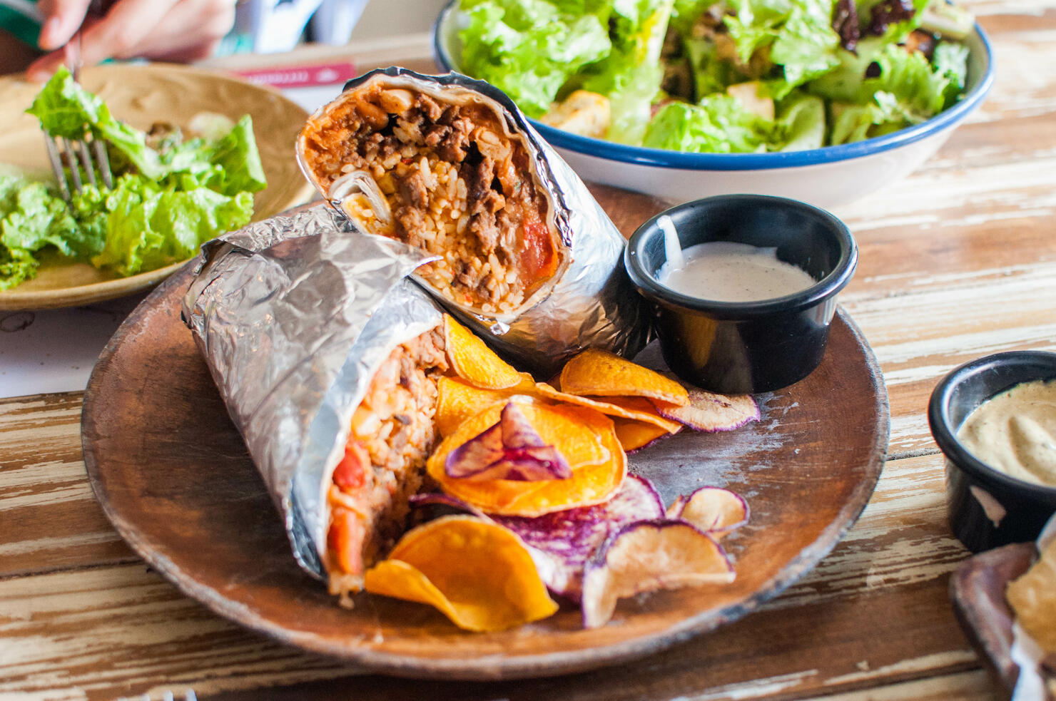 A close-up of burritos on a wooden plate