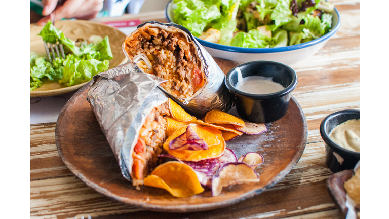 A close-up of burritos on a wooden plate