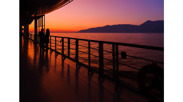 couple on a cruise ship at sunset