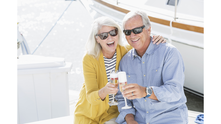 Senior couple on boat celebrating with champagne