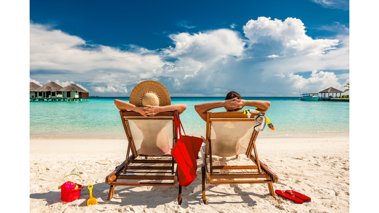 Couple in loungers on beach at Maldives