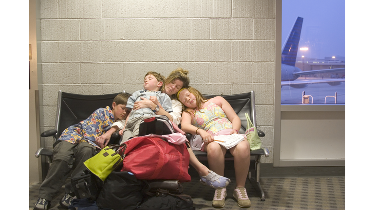 Family sleeping in waiting area of airport