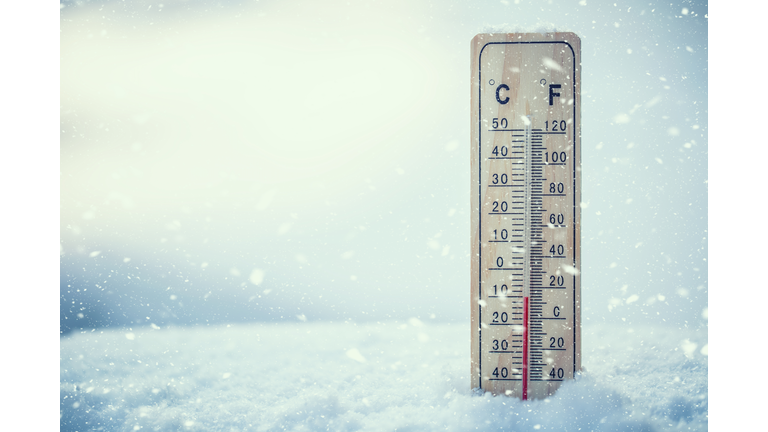 Thermometer on snow shows low temperatures under zero. Low temperatures in degrees Celsius and fahrenheit. Cold winter weather ten under zero