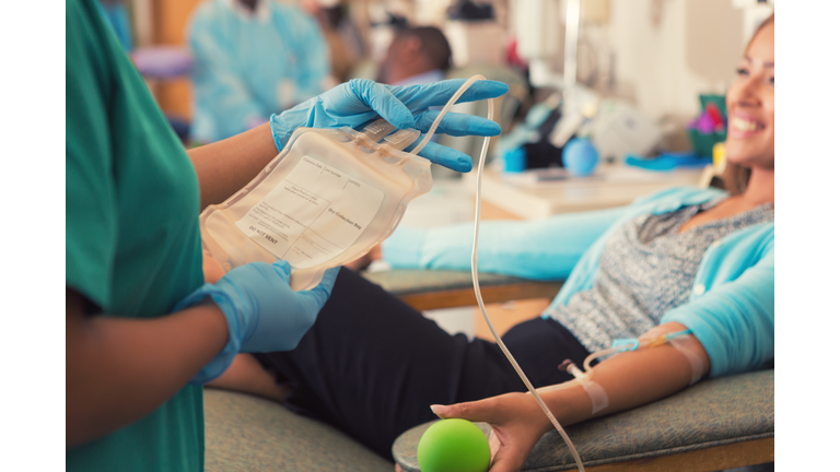 Phlebotomist preparing patient to donate blood in hospital lab