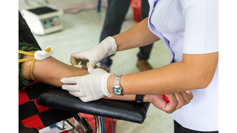 Midsection Of Nurse Taking Blood From Patient In Hospital