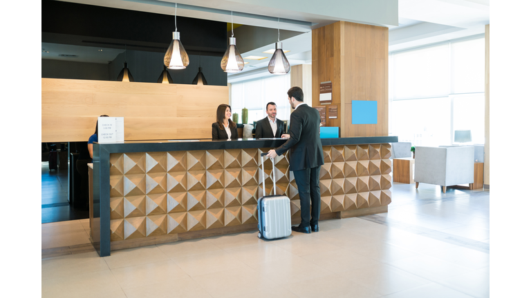 Happy Hotel Clerks Are Welcoming Professional At Counter