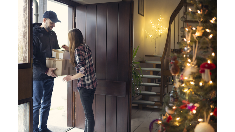 Teenager receiving Christmas packages delivered by postman