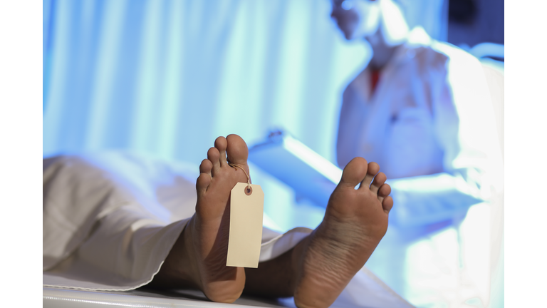 Medical Examiner with corpse in morgue.