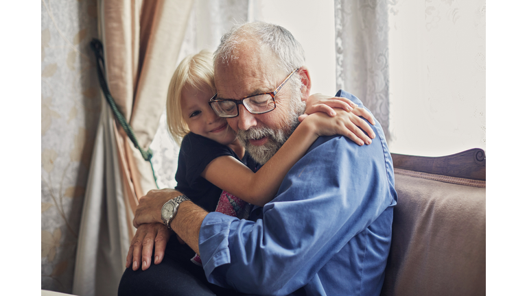 Little girl giving her Grandfather a hug