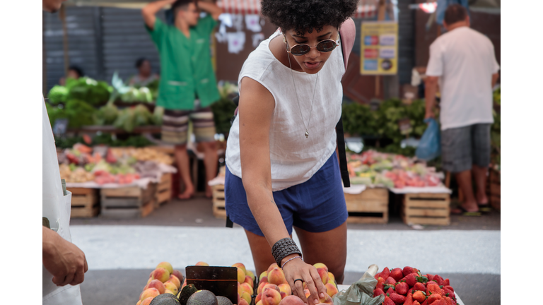 Woman shopping for fruits at a street market in the city of Rio de Janeiro