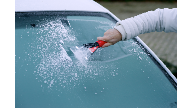 Scraping snow and ice from the car windscreen