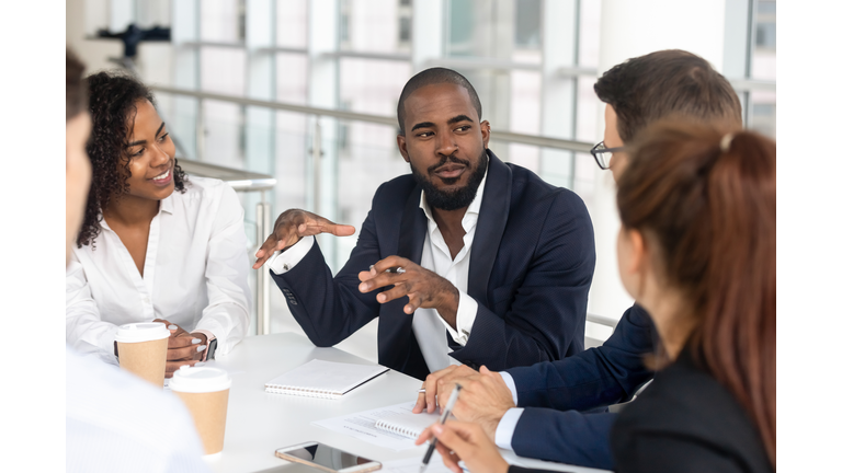 Black millennial boss leading corporate team during briefing in boardroom